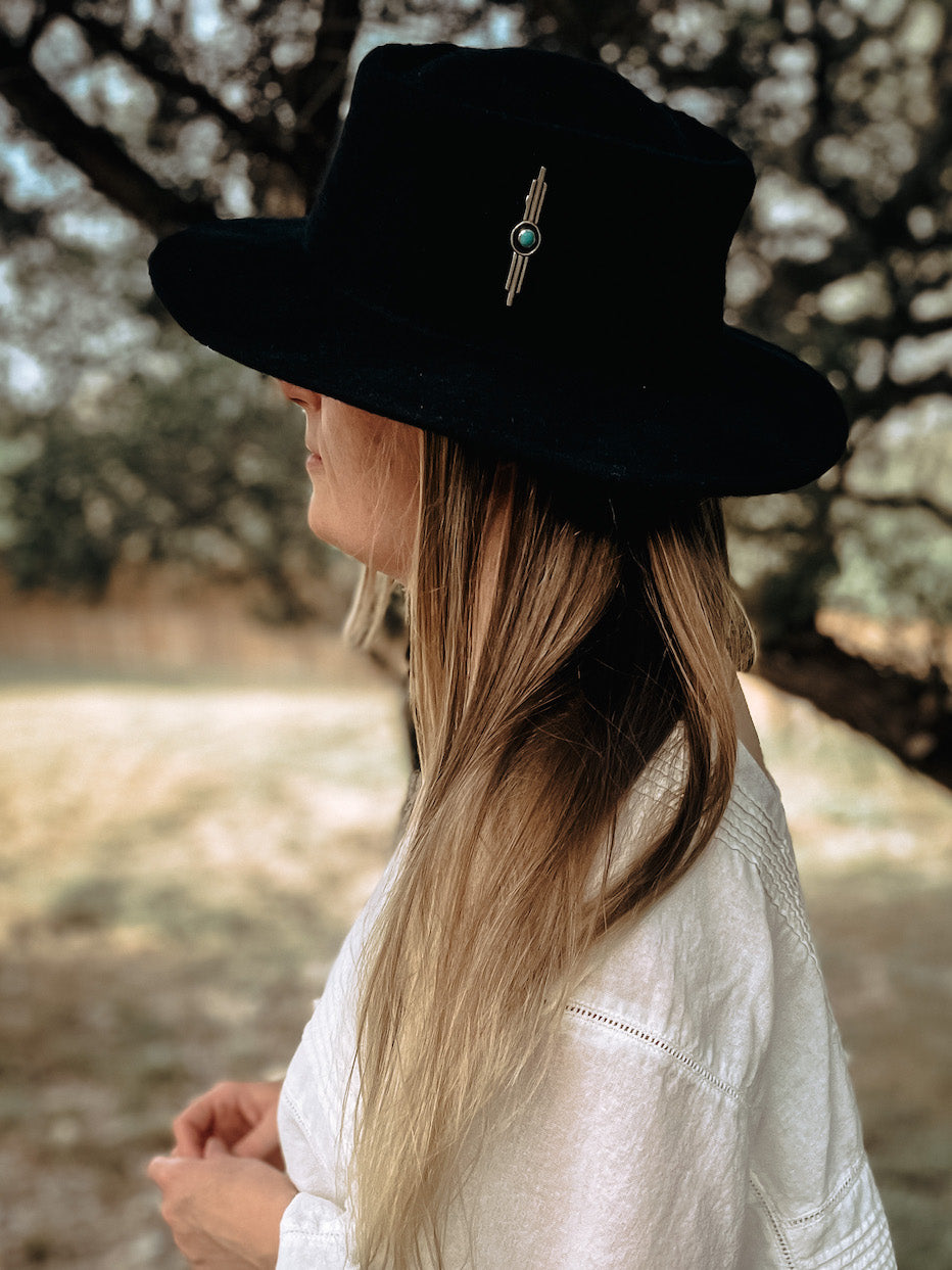 Vertical bar hatpin with round turquoise in middle worn on black hat.