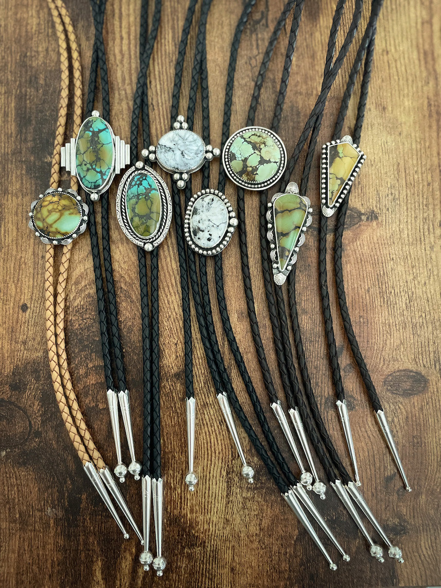 Eight turquoise and white buffalo leather bolos.