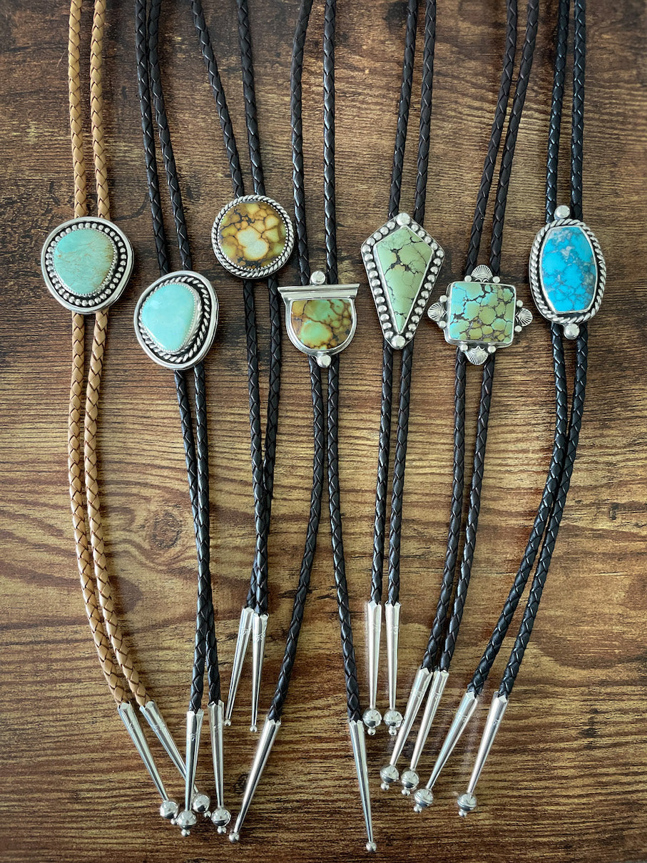 Seven turquoise leather bolos.