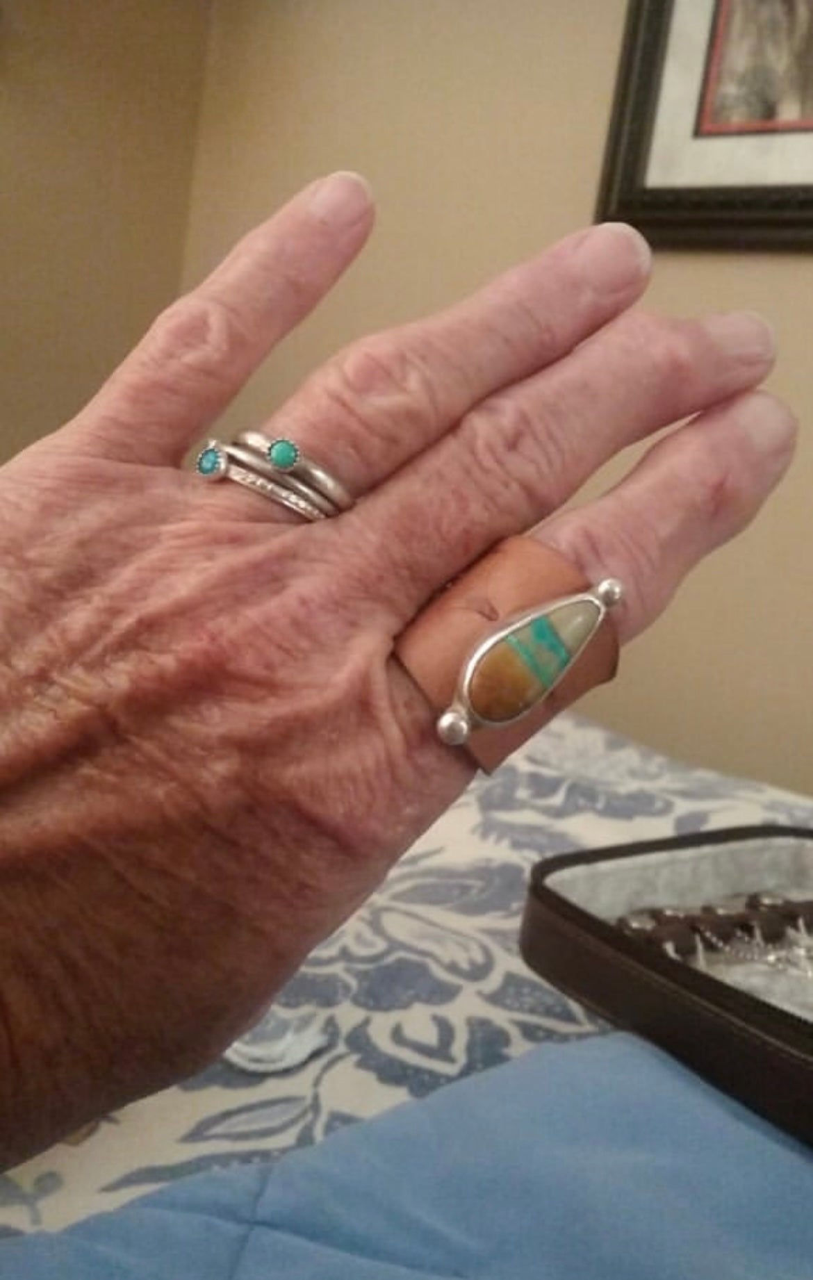 Customer photo wearing natural tan colored leather with blue and brown color turquoise bandana slide as a ring on first finger.