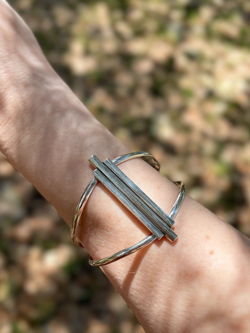 Art Deco sterling silver cuff bracelet worn on wrist outdoors in natural light.