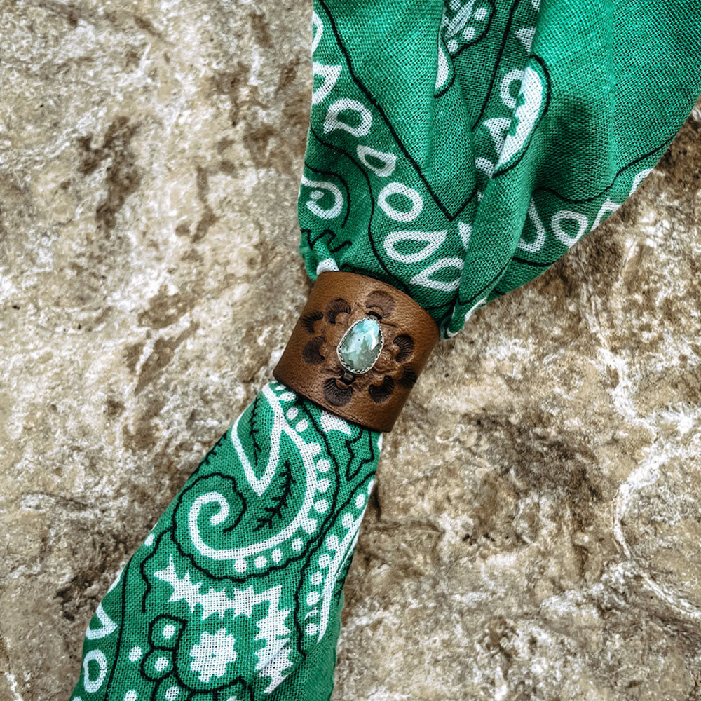 Round green turquoise set in sterling silver on brown stamped leather slide on green bandana.